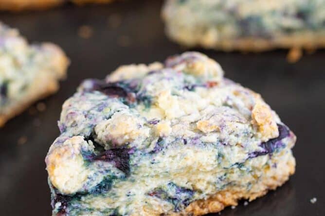 close up buttery blueberry scone on a baking sheet