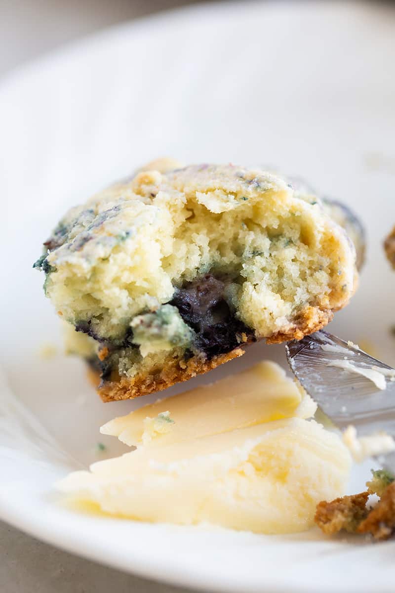 close up buttery blueberry scone on white plate