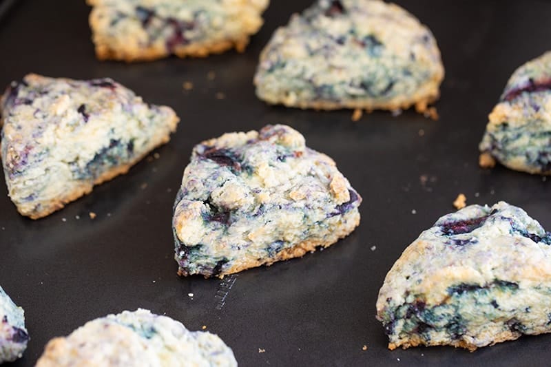 close up buttery blueberry scones on baking sheet