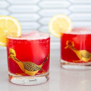 Cranberry Whiskey Sour in a vintage roadrunner decorated glass garnished with lemon