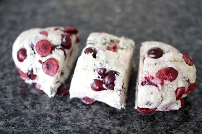Rolled dough of cherry scones cut into three equal pieces