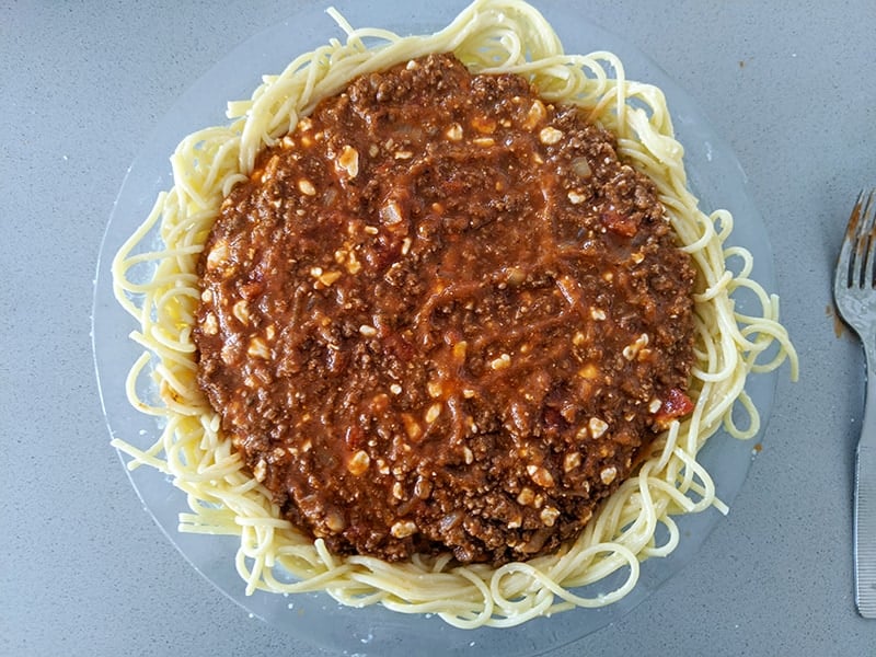 pasta crust with meat sauce on a large Pyrex plate 