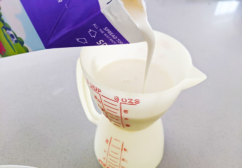 heavy cream poured into measuring cup