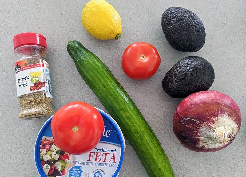 avocado salad ingredients consists of avocado, cucumber, tomatoes, lemon, feta, red onions and Greek seasoning