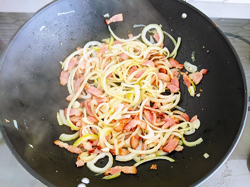 Fried onions and bacon in a large wok
