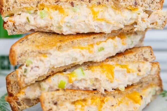 tuna melt sandwich pieces stacked on top of each other on a white plate