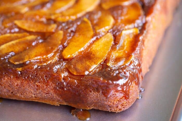 apple upside down cake with caramel dripping down the corner