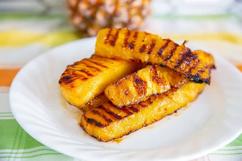 Grilled Pineapple slices on a while plate