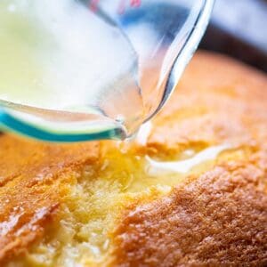 lemon glaze being poured over a lemon loaf