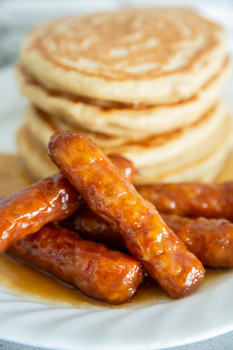 pork sausages on a plate with a stack of pancakes