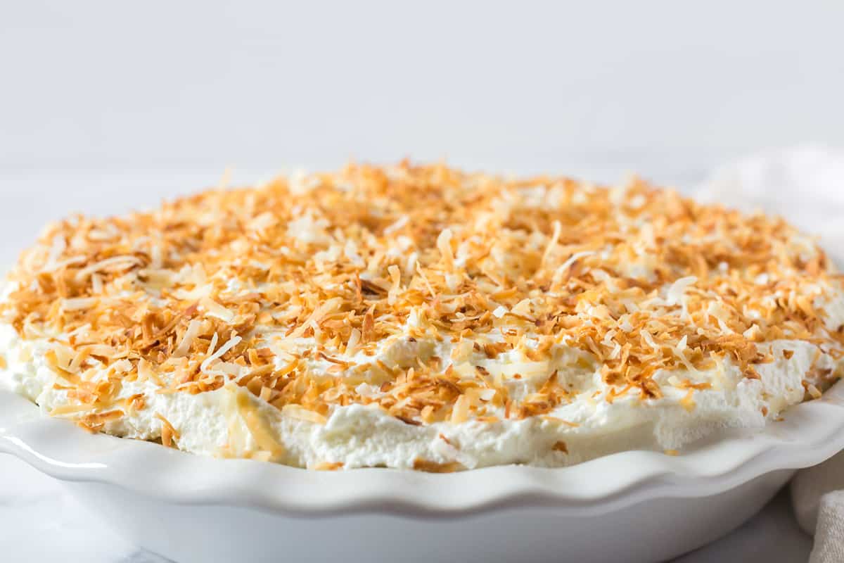 coconut cream pie in a white pie plate 