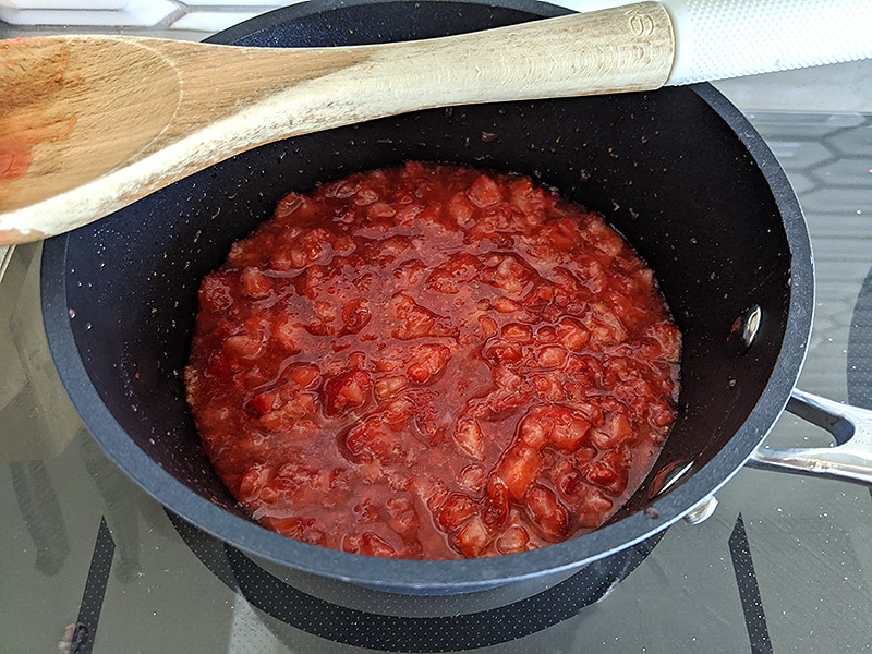 strawberries and sugar in a pot on the stove