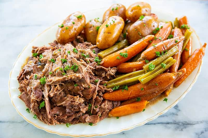 pot roast on a white plate with vegetables 