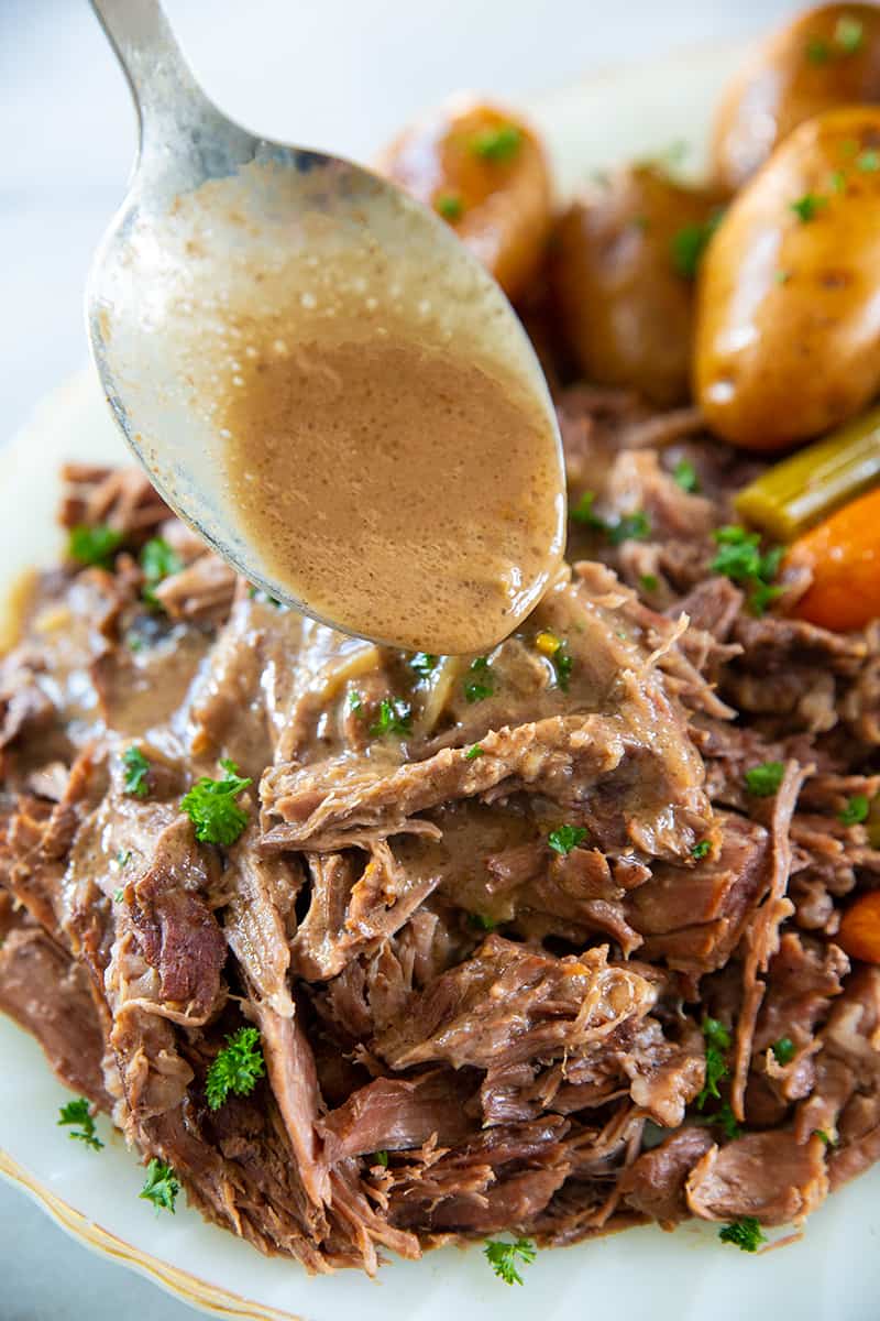 spooning gravy over pot roast