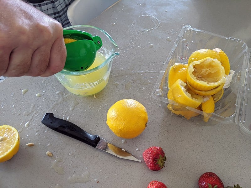 hand squeezing lemons for lemon juice