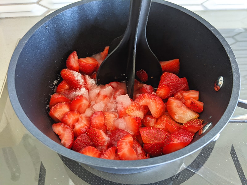 crushing the strawberries and sugar in a pot