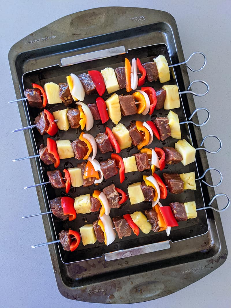 raw beef kabobs on a baking sheet