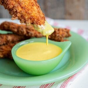 Honey Mustard Sauce in a green jadeite serving dish with chicken fingers