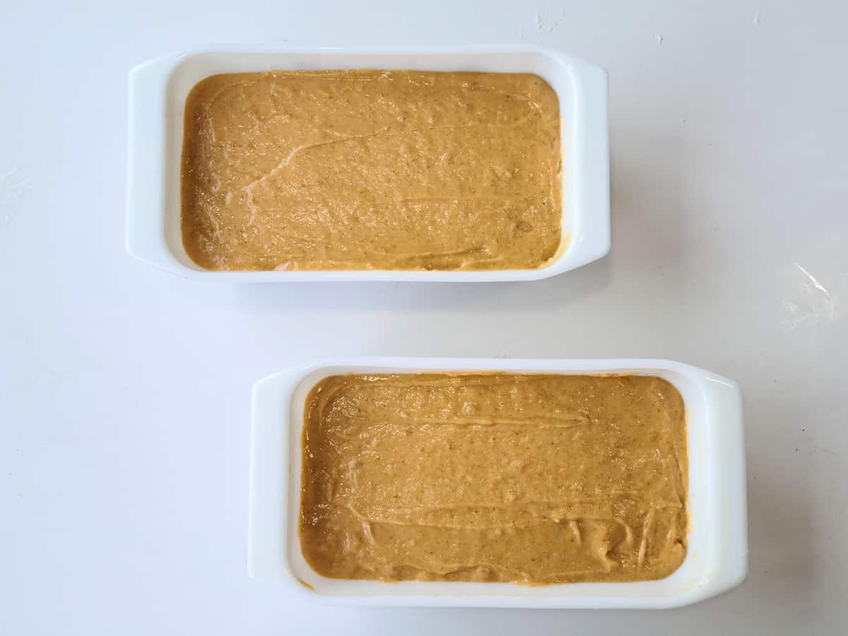 Pumpkin Banana Bread batter in two greased standard loaf pans