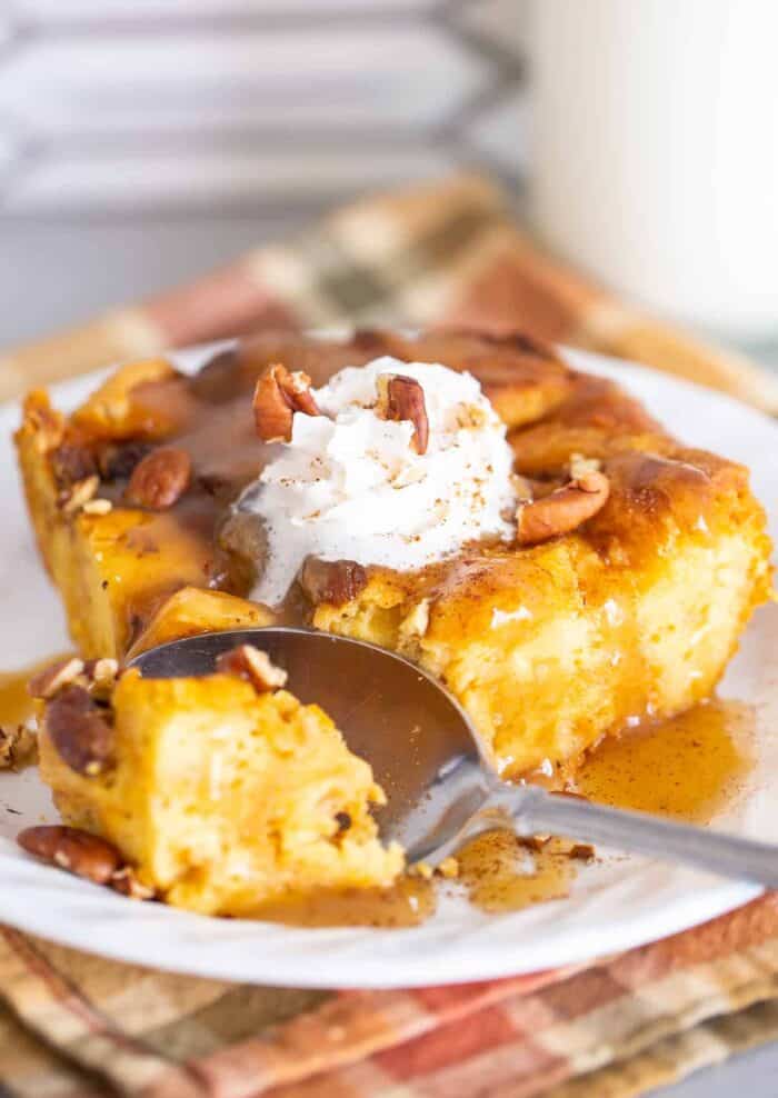Spooning the Pumpkin Bread Pudding on a white plate