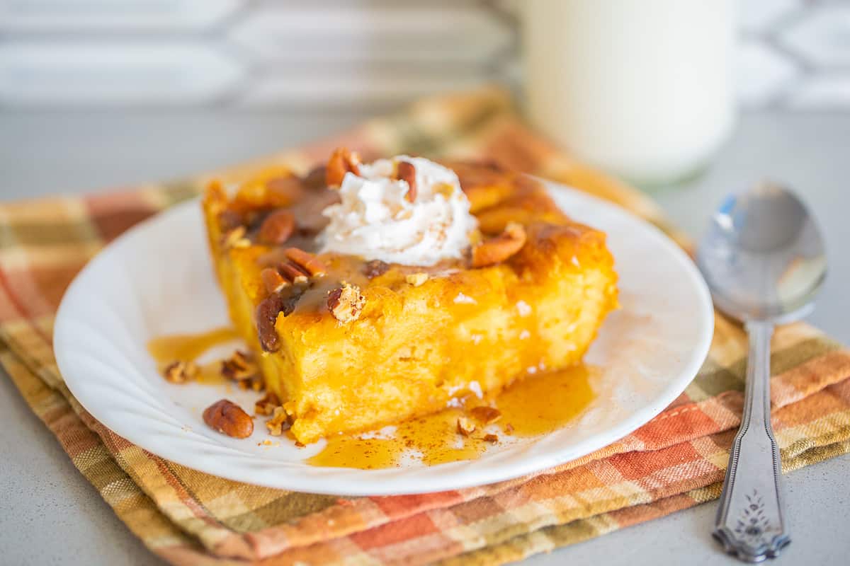 Pumpkin Bread Pudding on a white plate with a spoon on the side