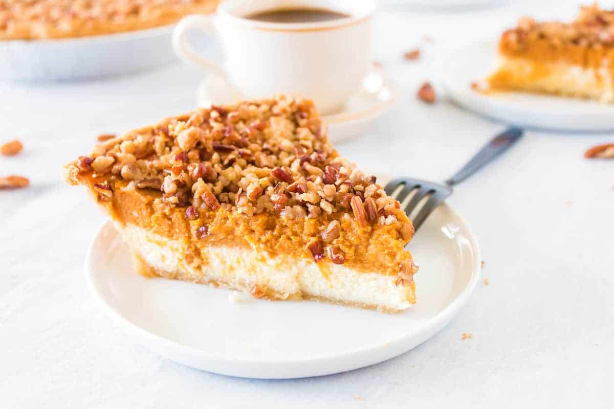 A slice of Pumpkin Cheesecake Pie in a white plate