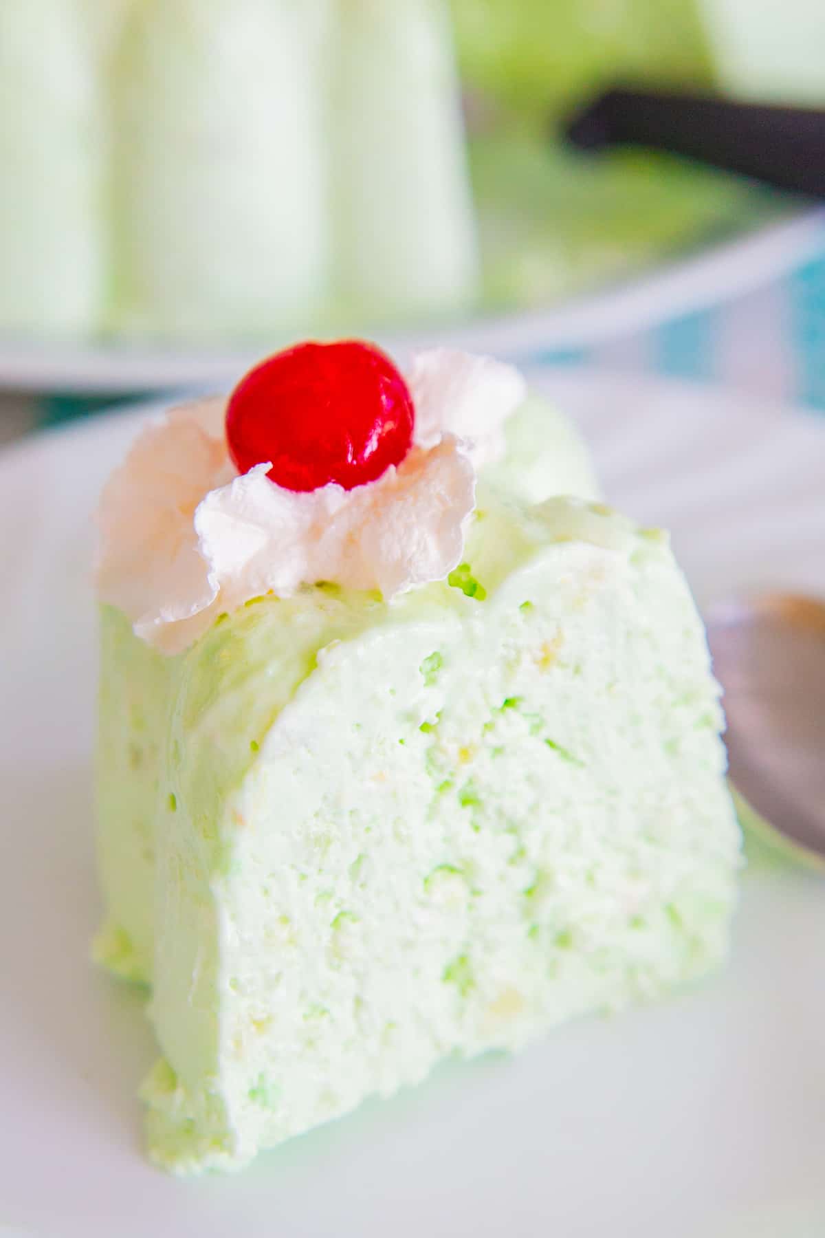 a Slice of Seafoam Salad topped with Whipped Cream and Red Cherry