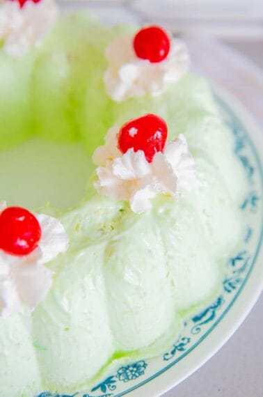 Close up of Seafoam Salad topped with Whipped Cream and Red Cherries