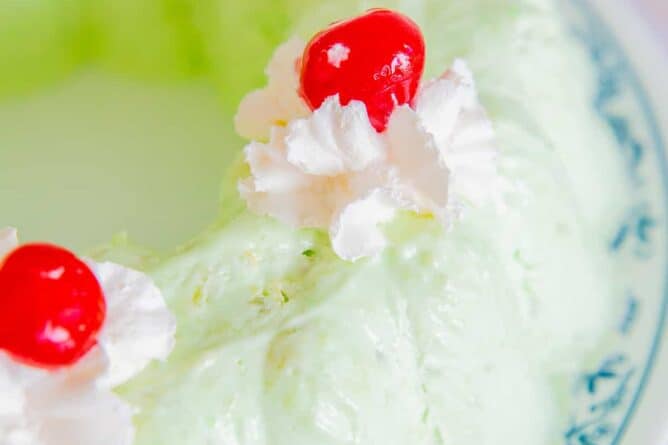 Close up of Seafoam Salad topped with Whipped Cream and Red Cherries