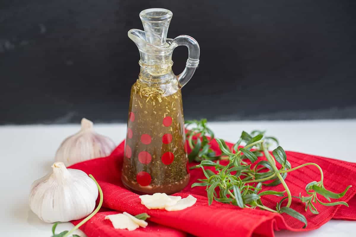 red cloth underneath the oil and vinegar based Italian Dressing in a transparent container