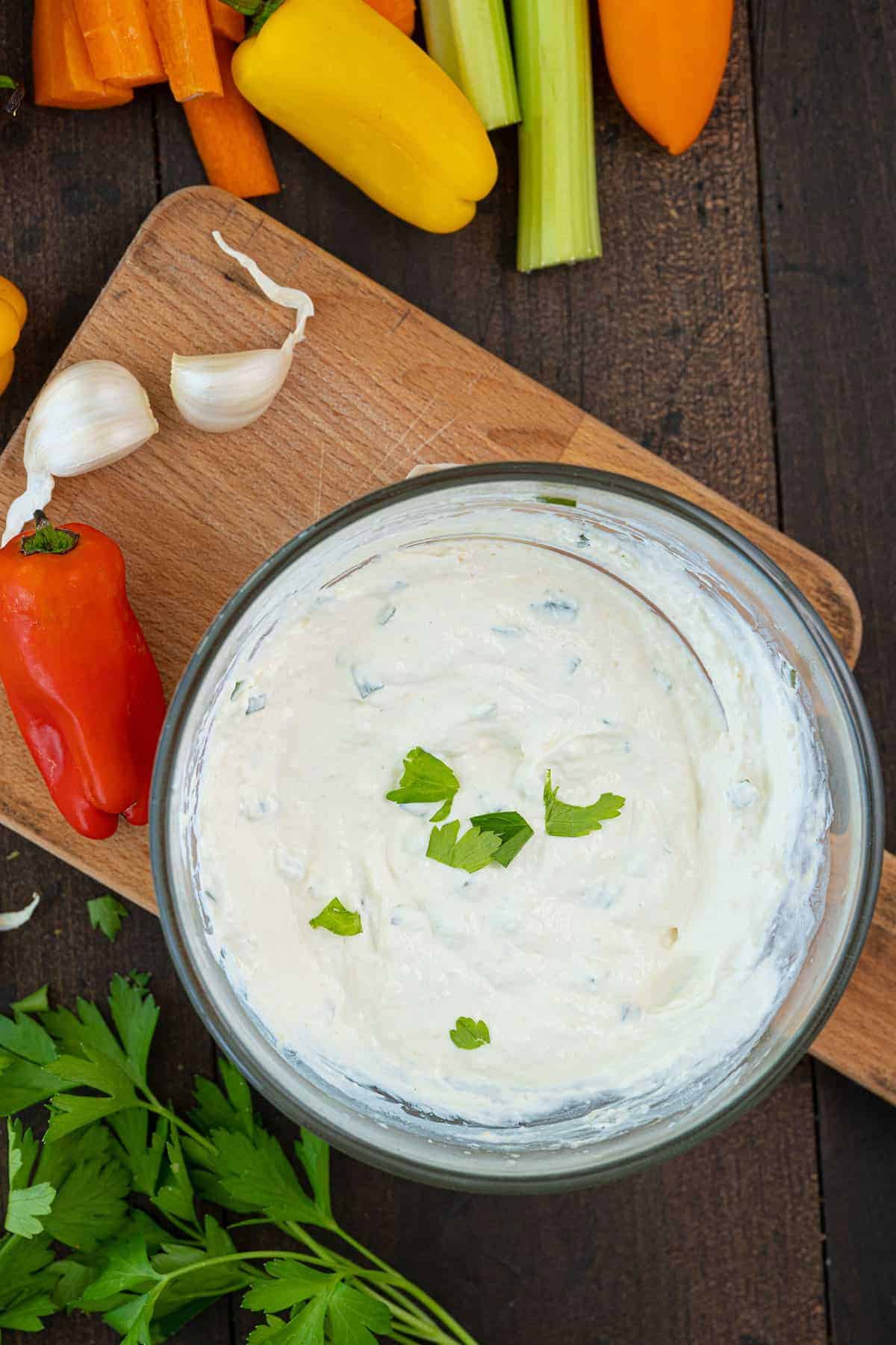 horseradish sauce in a large bowl with vegetables surrounding it 