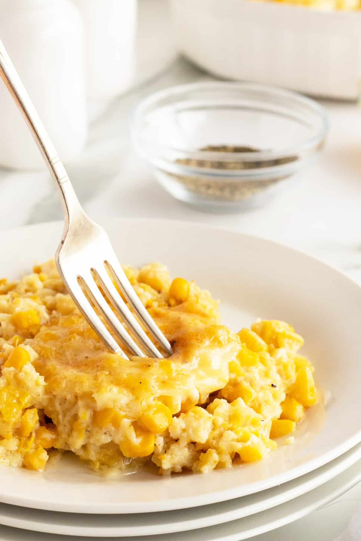 creamy corn pudding slice with a fork in it