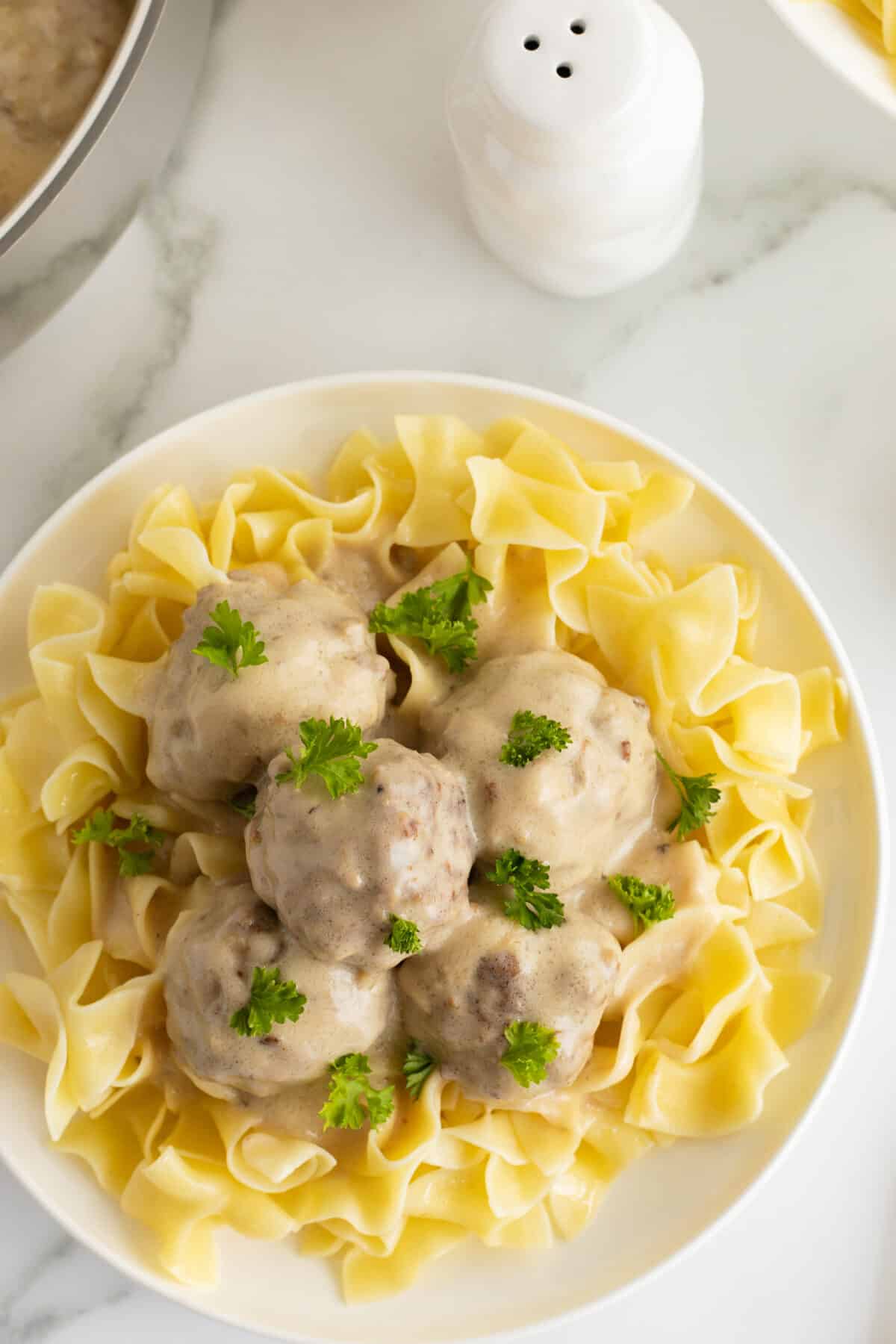 creamy swedish meatballs on a plate with pasta 