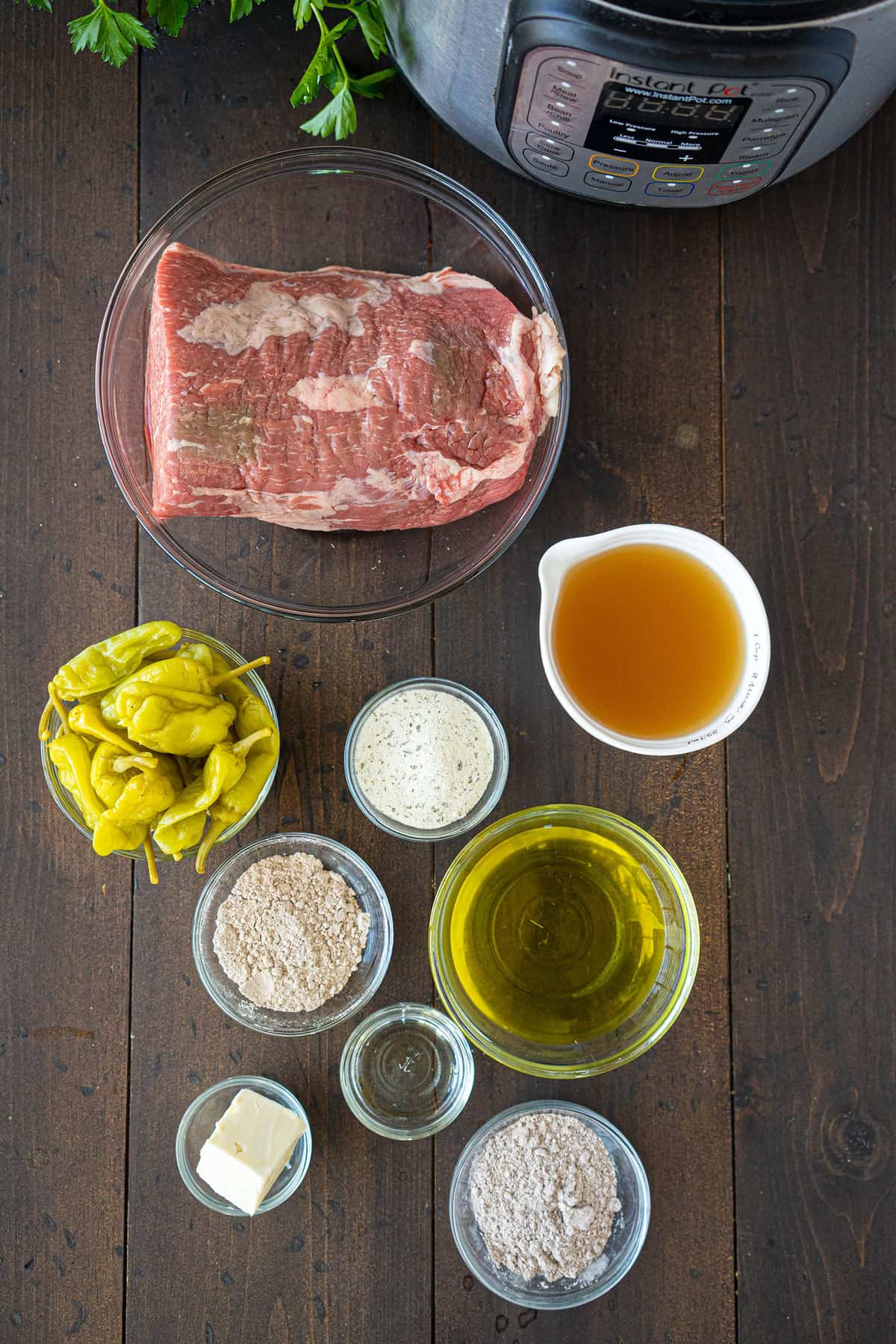 The ingredients for a Mississippi pot roast, laid out in individual bowls next to an Instant Pot