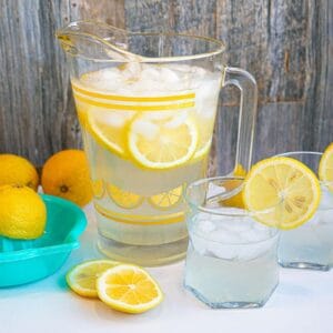 Lemon Water on the counter in two glasses with a pitcher in the background