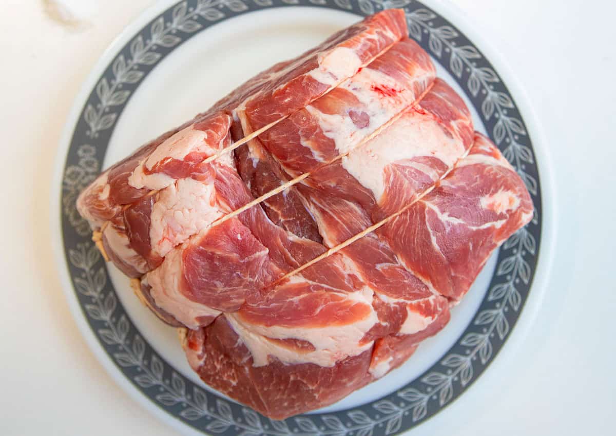 raw pork shoulder roast on a plate 