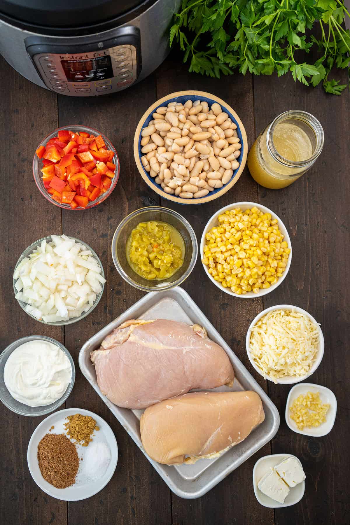 All the ingredients for the recipe, laid out in seperate bowls on a talbe by an Instant Pot