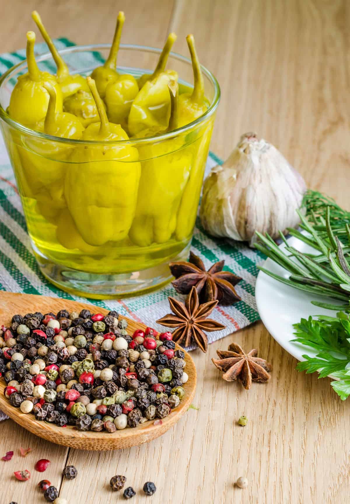 Close up of the spices used alongside some Pepperoncini peppers. 