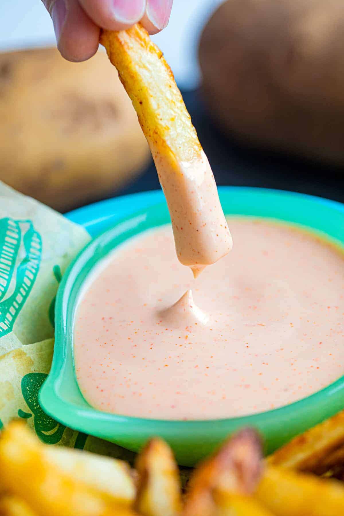 Dipping French fries into fry sauce