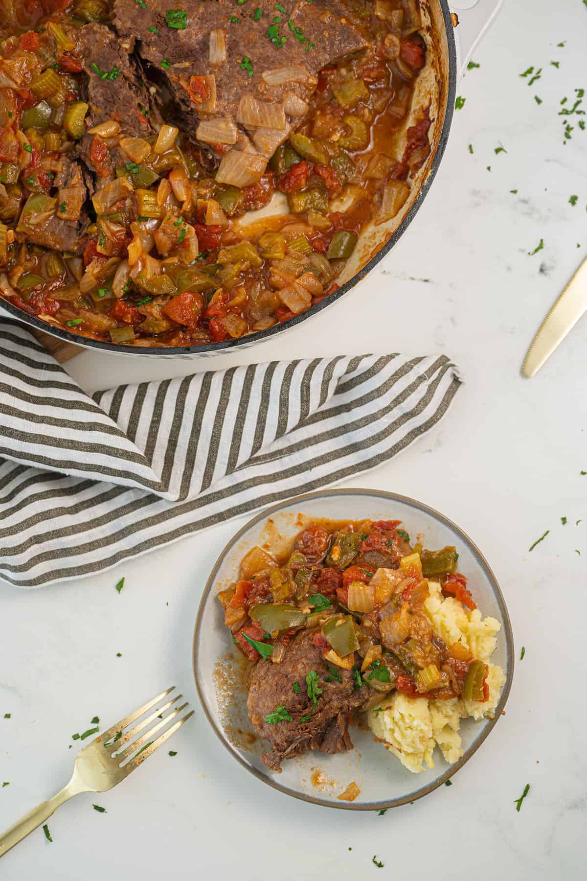 Swiss steak in braising pan and on a white plate