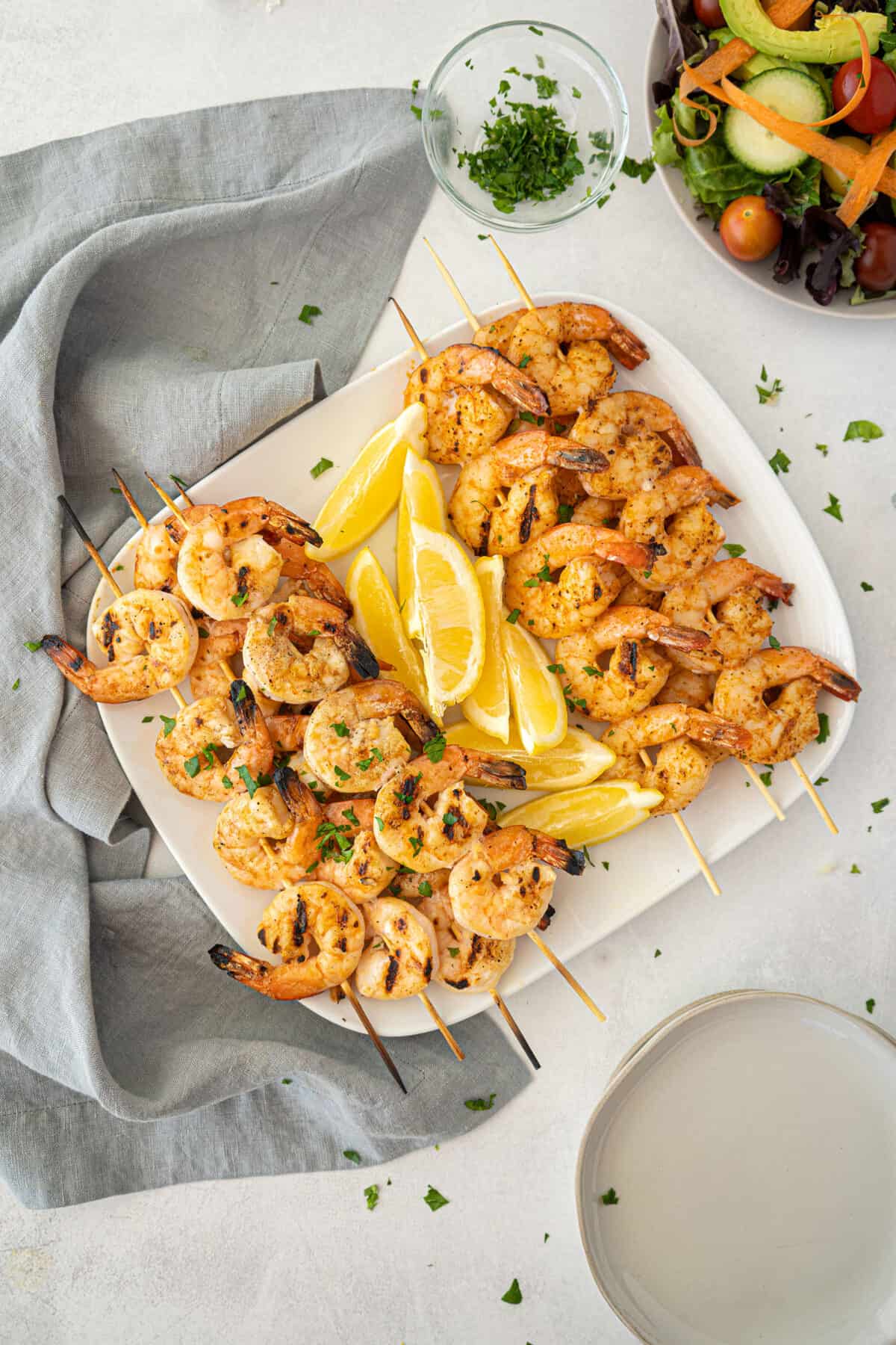 two kinds of grilled shrimp on a white platter 