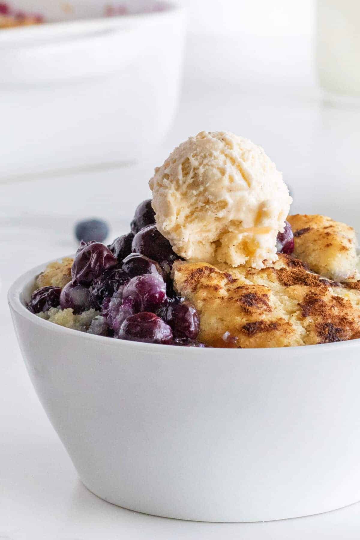 close up of blueberry cobbler in a white bowl