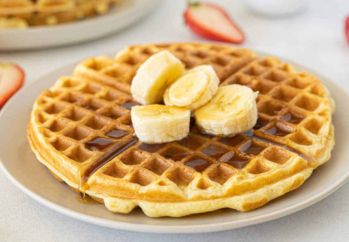 buttermilk waffles with bananas and syrup on top