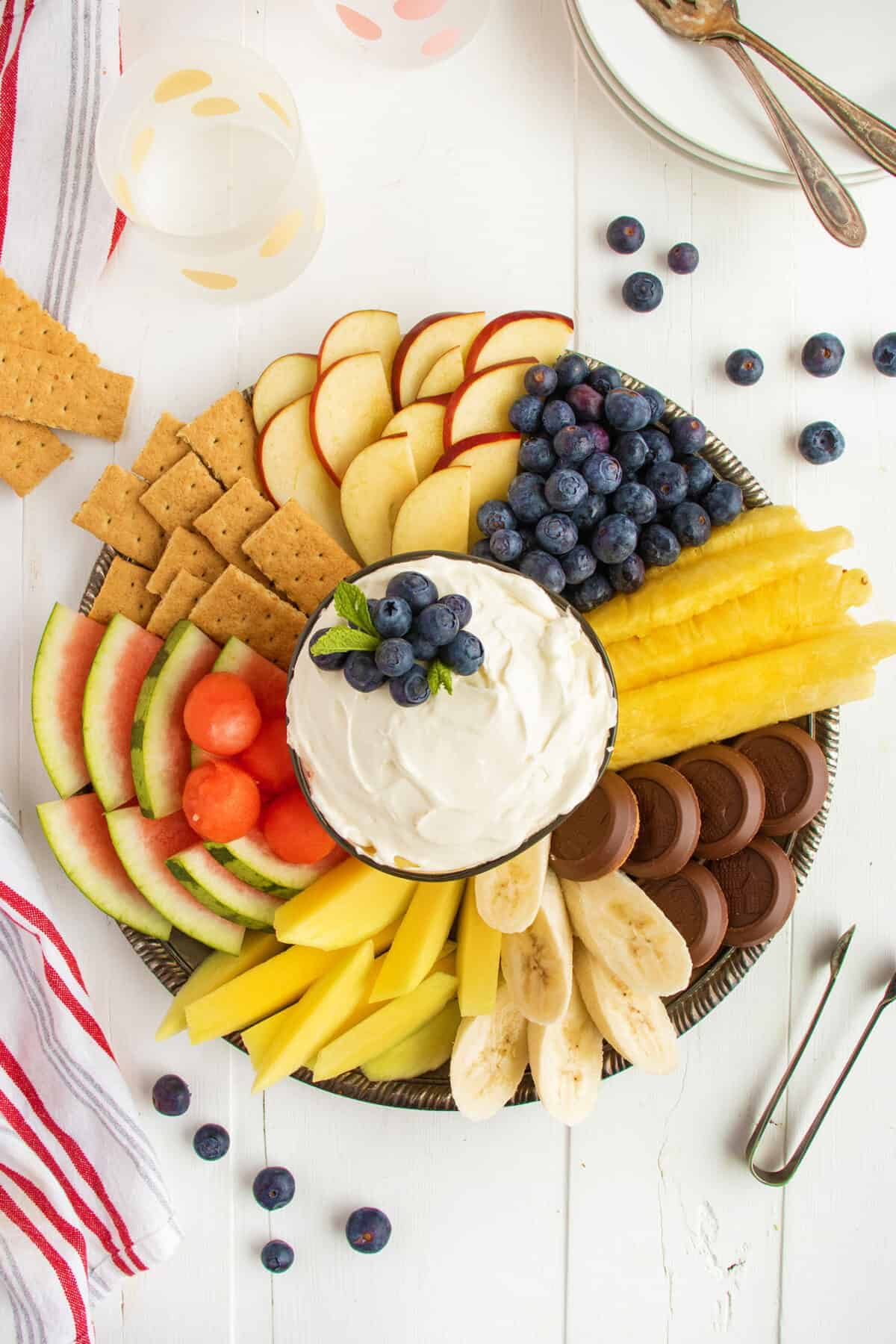 cream cheese dip topped with blueberries and surrounded by fruit and cookies 