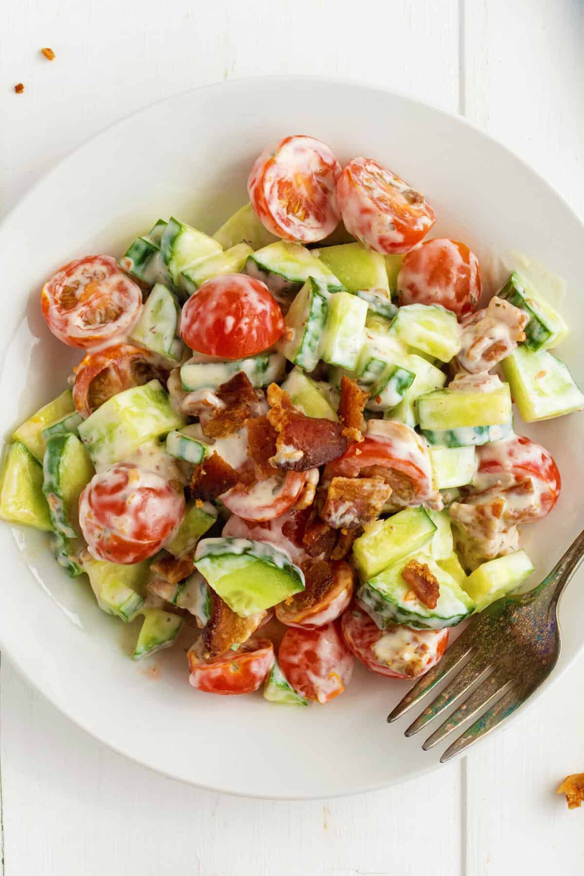 Cucumber tomato salad with bacon on top