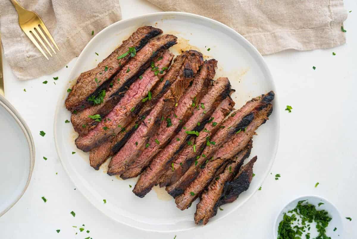 marinated flank steak on a white plate