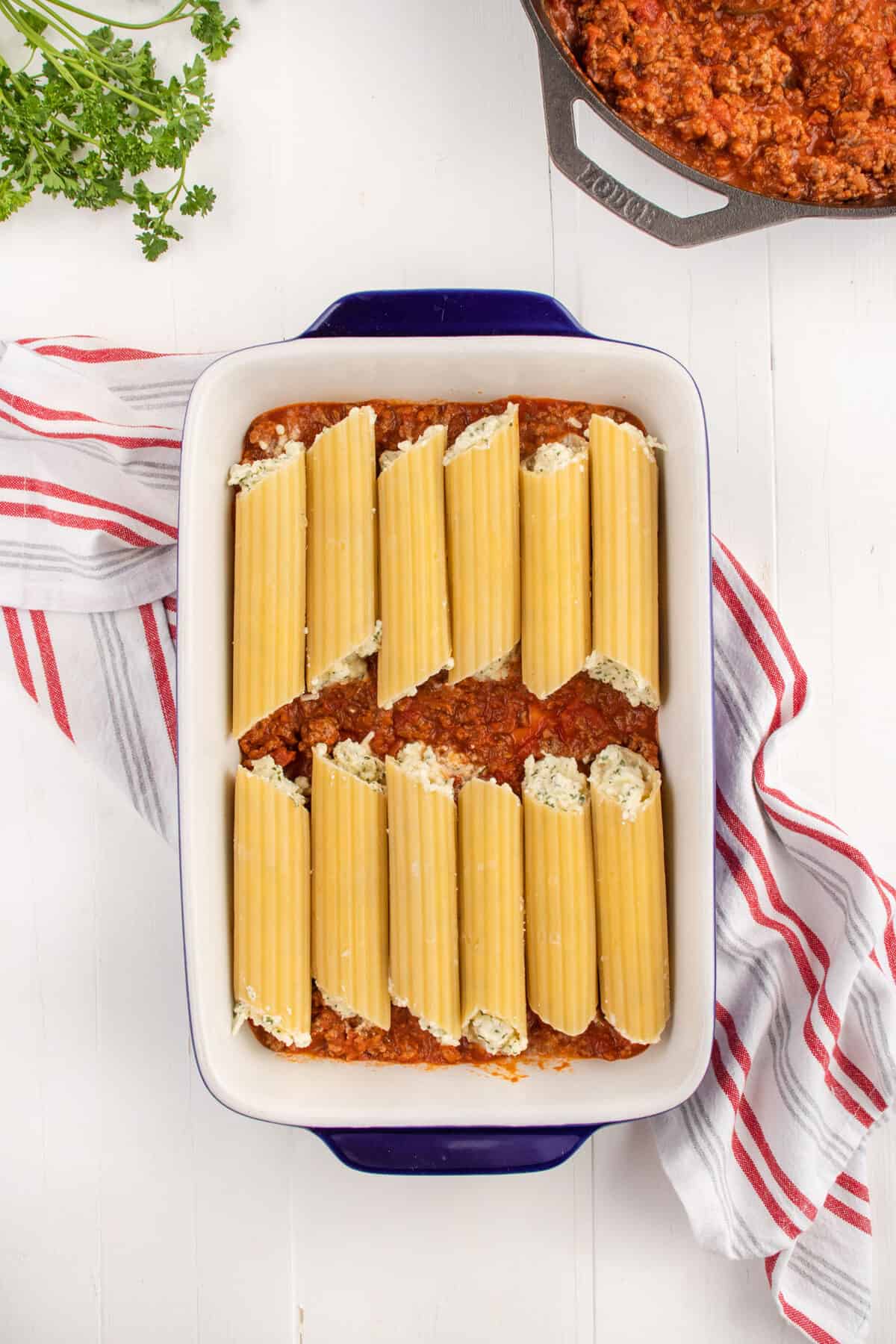 filling manicotti pasta and placing them into the baking pan