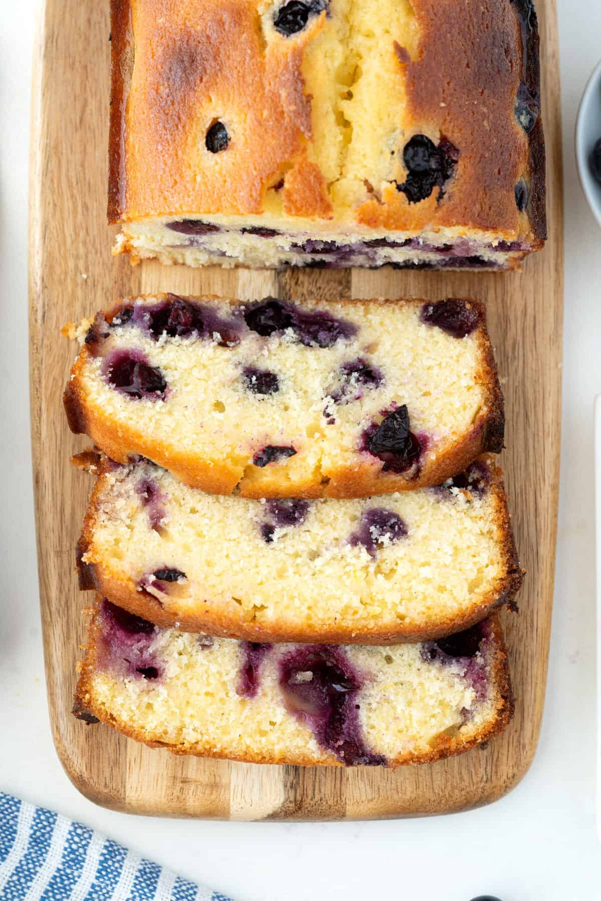 slices of lemon blueberry bread on a wooden board 