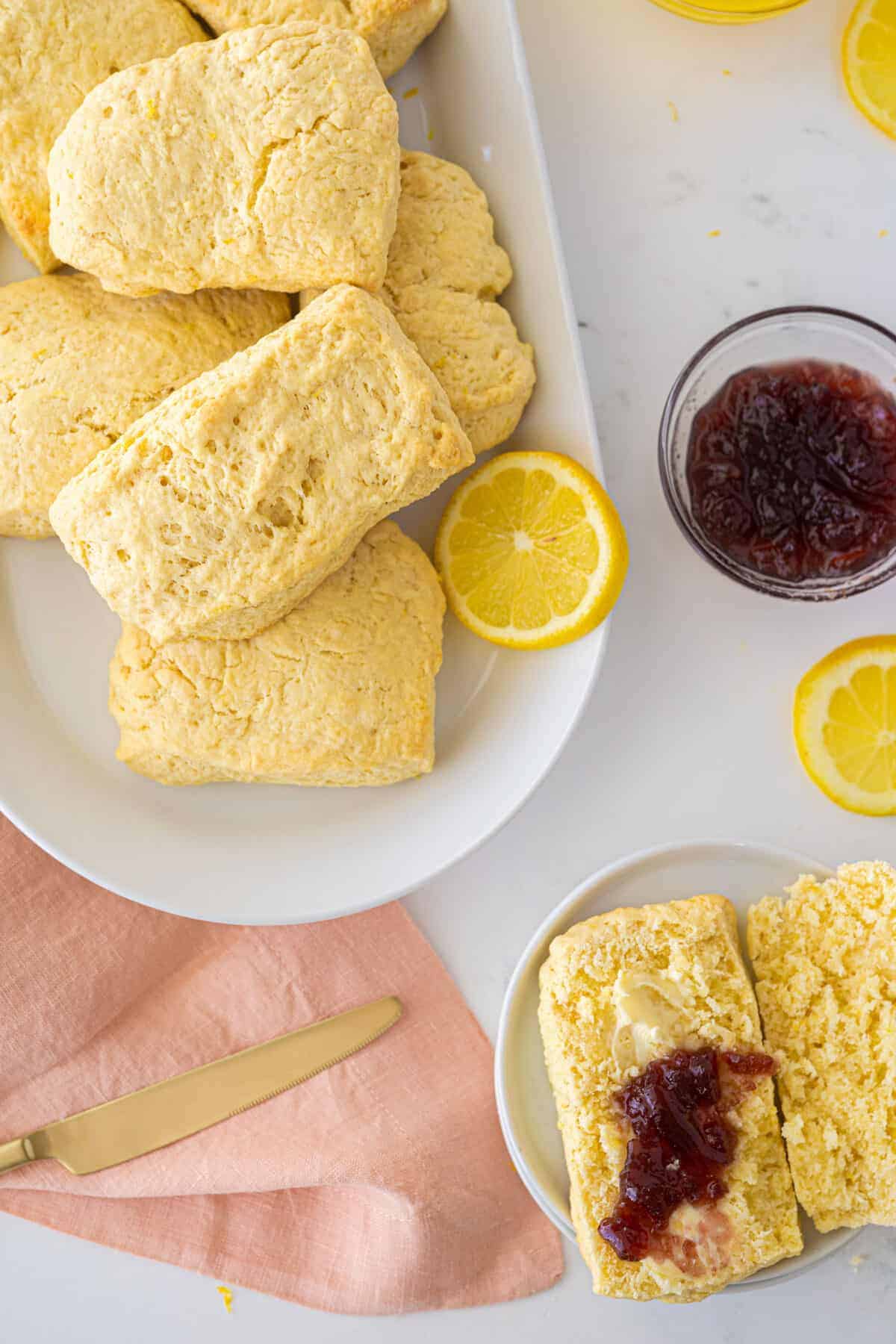 lemon scones on a white plate with raspberry jam on top