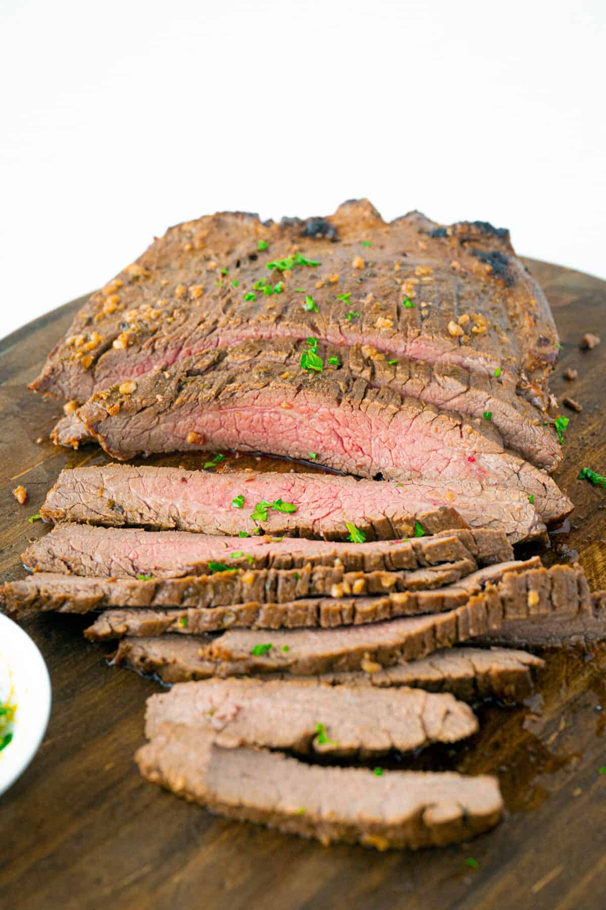 London broil sliced on a wooden board